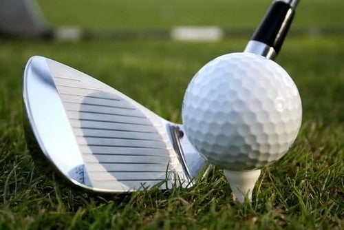 Close on golf club lining up to hit golf ball