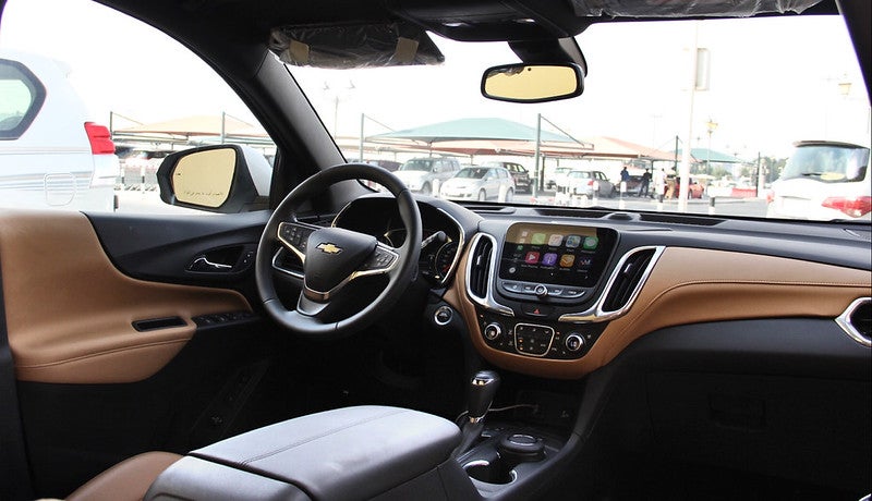 View inside 2021 Chevy Equinox from rear seats with empty driver seats and touchscreen display on