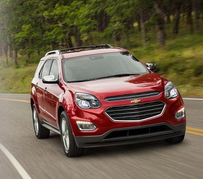 Red Chevy Equinox Driving By a Forest | Rydell Chevrolet of Grand Forks, ND