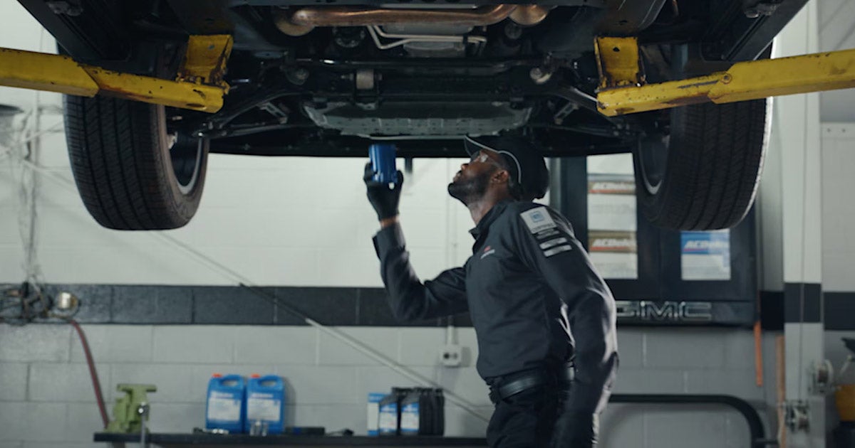 Professional automotive technician performing brake system inspection and maintenance service