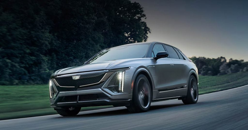 Cadillac LYRIQ driving down an empty road.