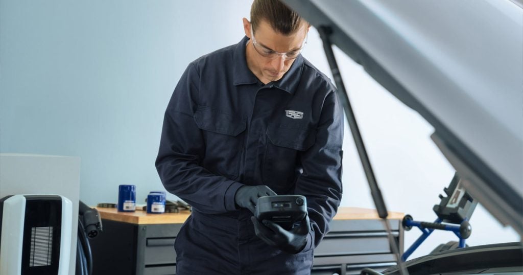 Cadillac Service Technician checking a battery on a Cadillac vehicle.
