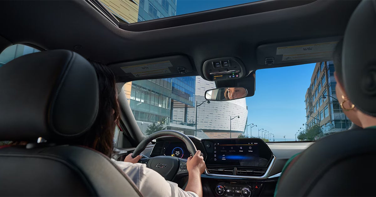 2025 Chevrolet Trax interior view showing panoramic sunroof with driver and passenger in urban setting