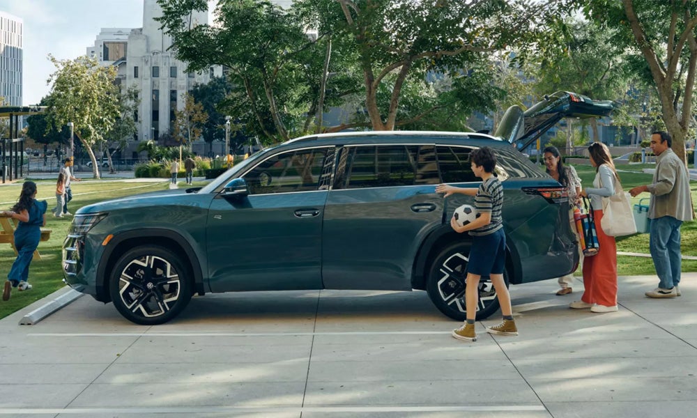 Family standing beside a Volkswagen Atlas three-row SUV