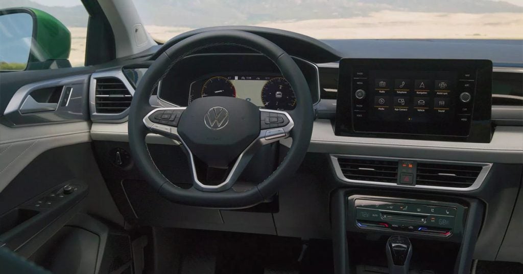 Volkswagen Taos interior dashboard with steering wheel, digital cluster, and touchscreen infotainment system