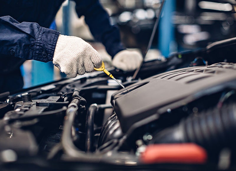 Technician checking a Buick SUV engine during routine maintenance service.