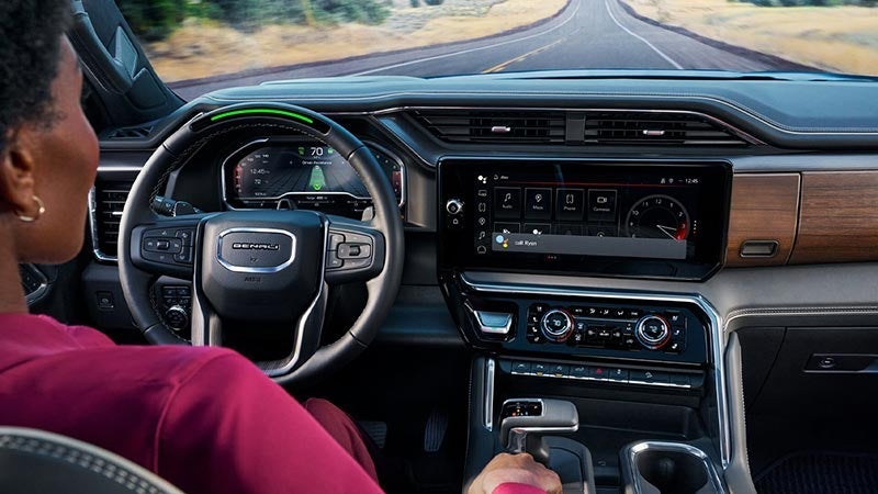 A driver sitting behind the wheel while Super Cruise controls the vehicle.