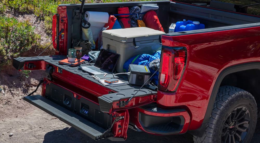 Gear is shown in the bed of a red 2023 GMC Sierra 1500 AT4X.
