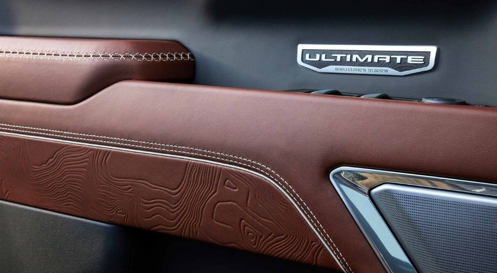 A close up shows brown leather trim details in a 2023 GMC Sierra 1500 Denali Ultimate.