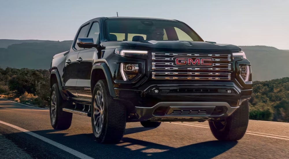 Black 2025 GMC Canyon Denali driving from a dealer with GMC trucks for sale near Ripley.