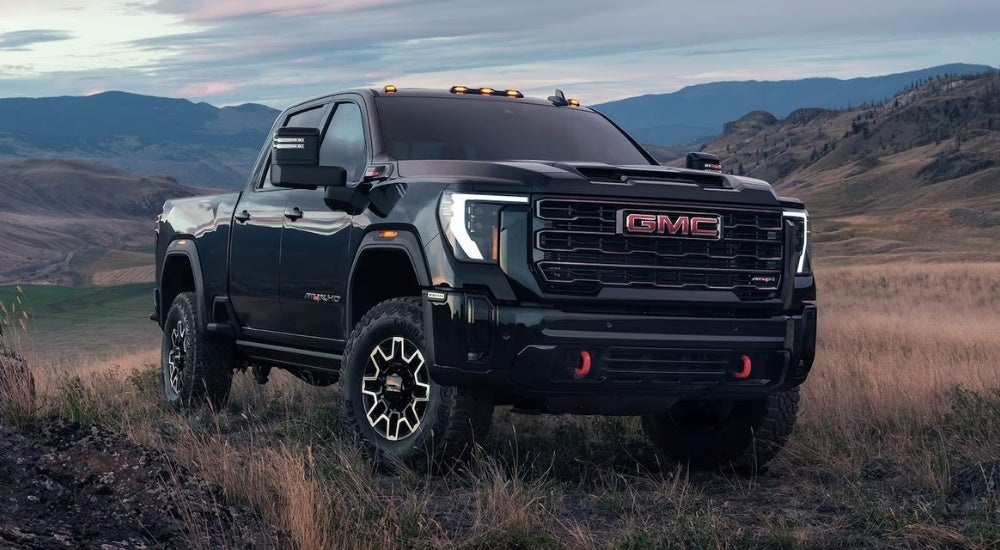 Black 2026 GMC Sierra 2500 HD AT4X parked on dry grass