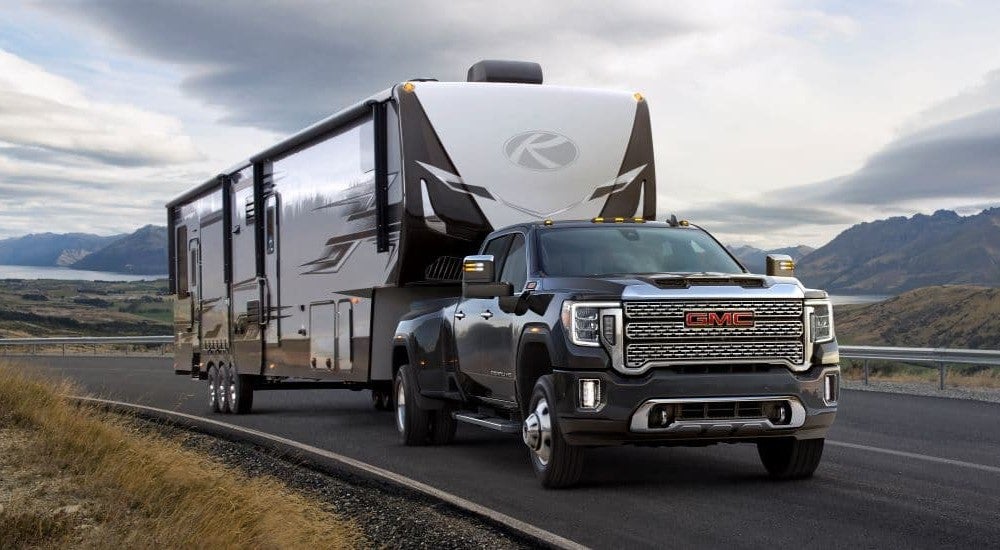 A black 2021 GMC Sierra 3500 towing a camper