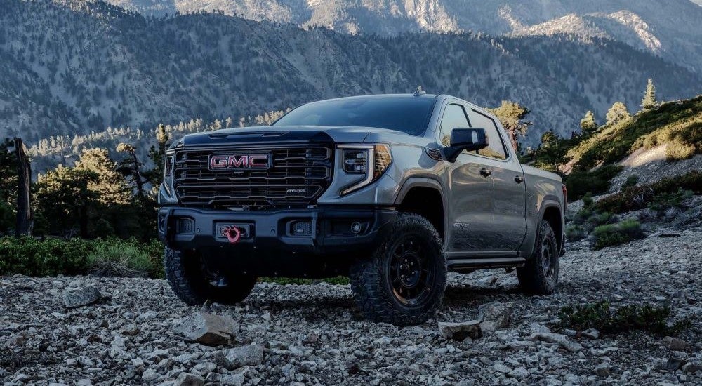 A grey 2024 GMC Sierra 1500 AT4 AEV is shown from the front at an angle after leaving a Ripley GMC dealer.