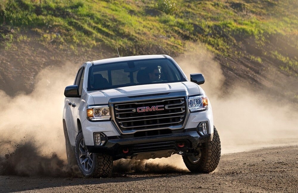 White GMC truck driving in the dirt