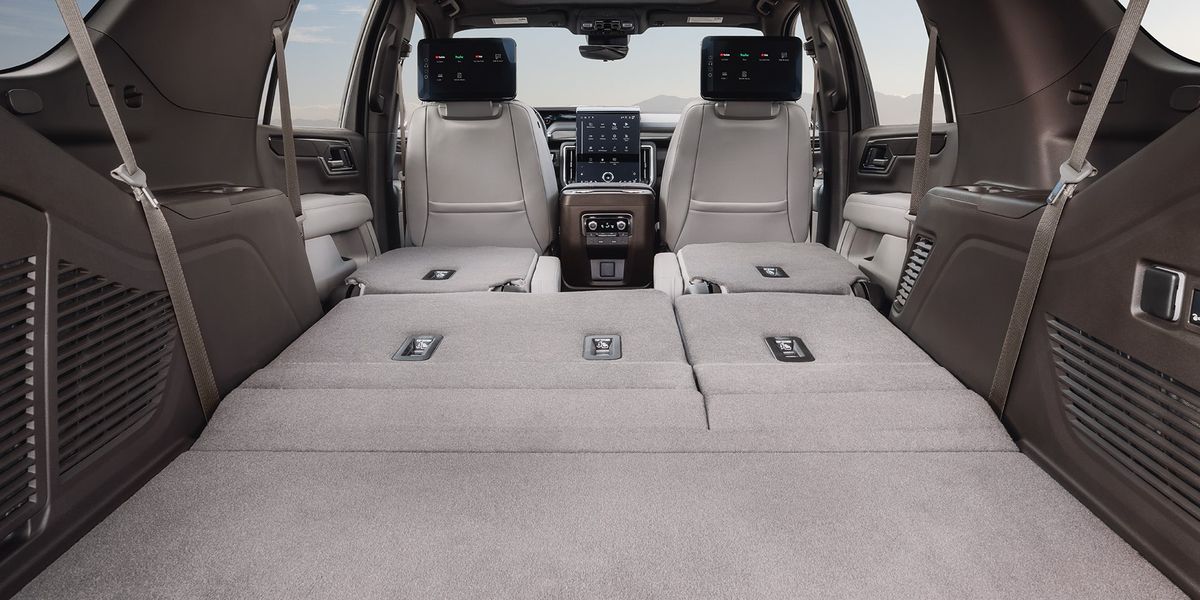 2026 GMC Yukon cargo area with rear seats folded and rear-seat entertainment screens