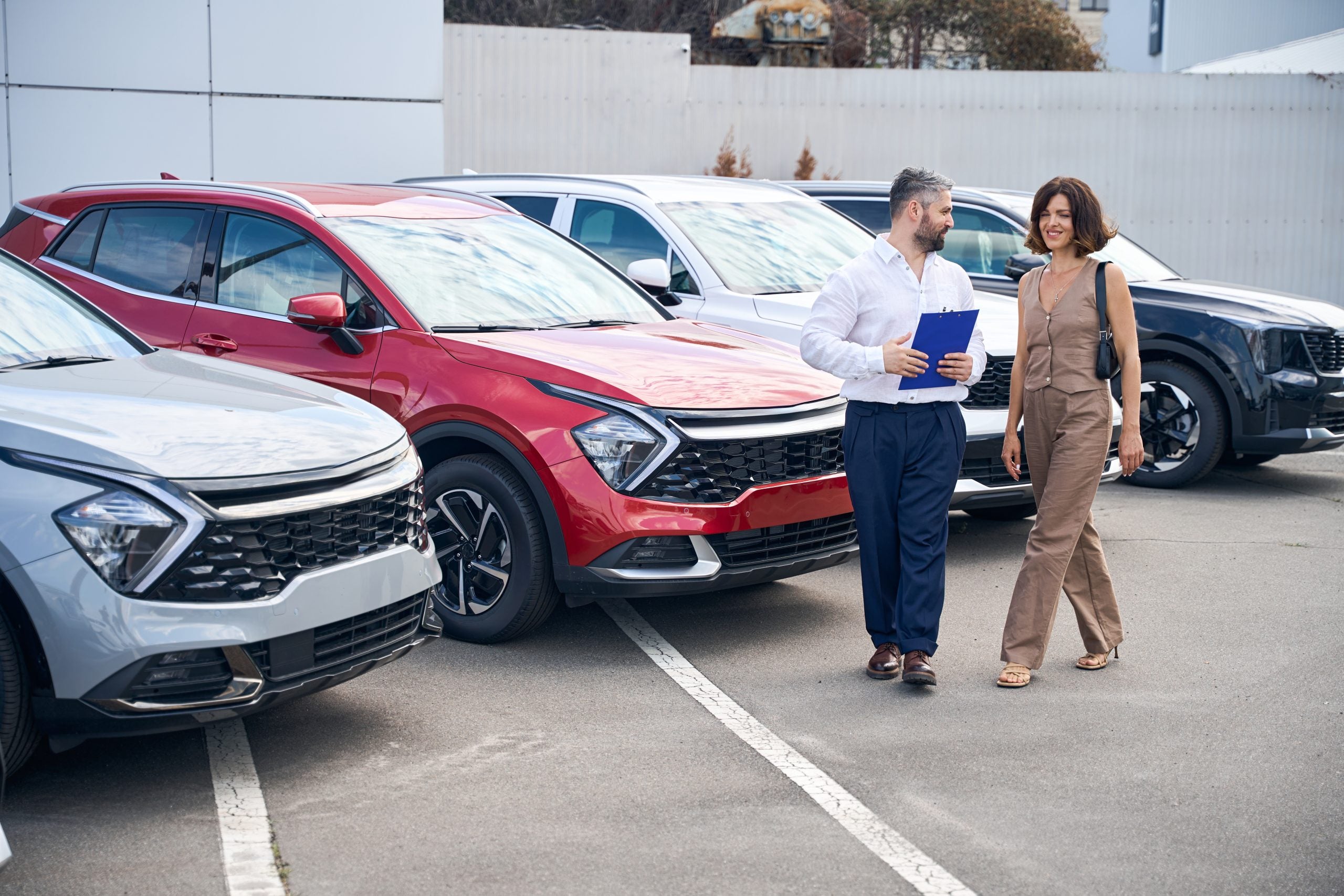 Customer and sales rep talking near used cars