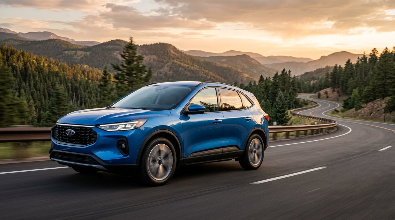 A blue Ford SUV drives along a curving mountain road framed by evergreen trees at sunset. (Representative image for illustration purposes only. Actual vehicle may vary based on trim and configuration.)
