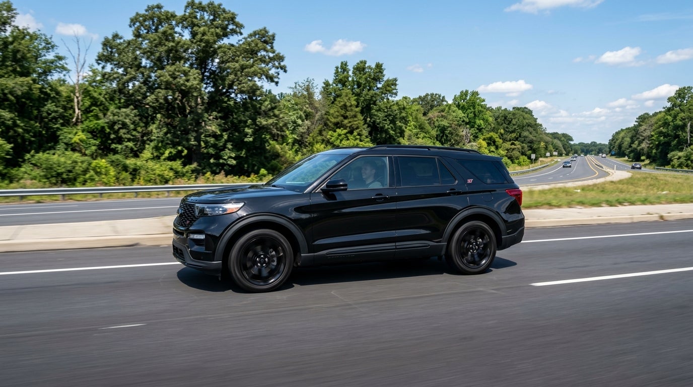 Black Ford Explorer ST SUV driving on a highway under a blue sky. (Representative image for illustration purposes only. Actual vehicle may vary based on trim and configuration.)