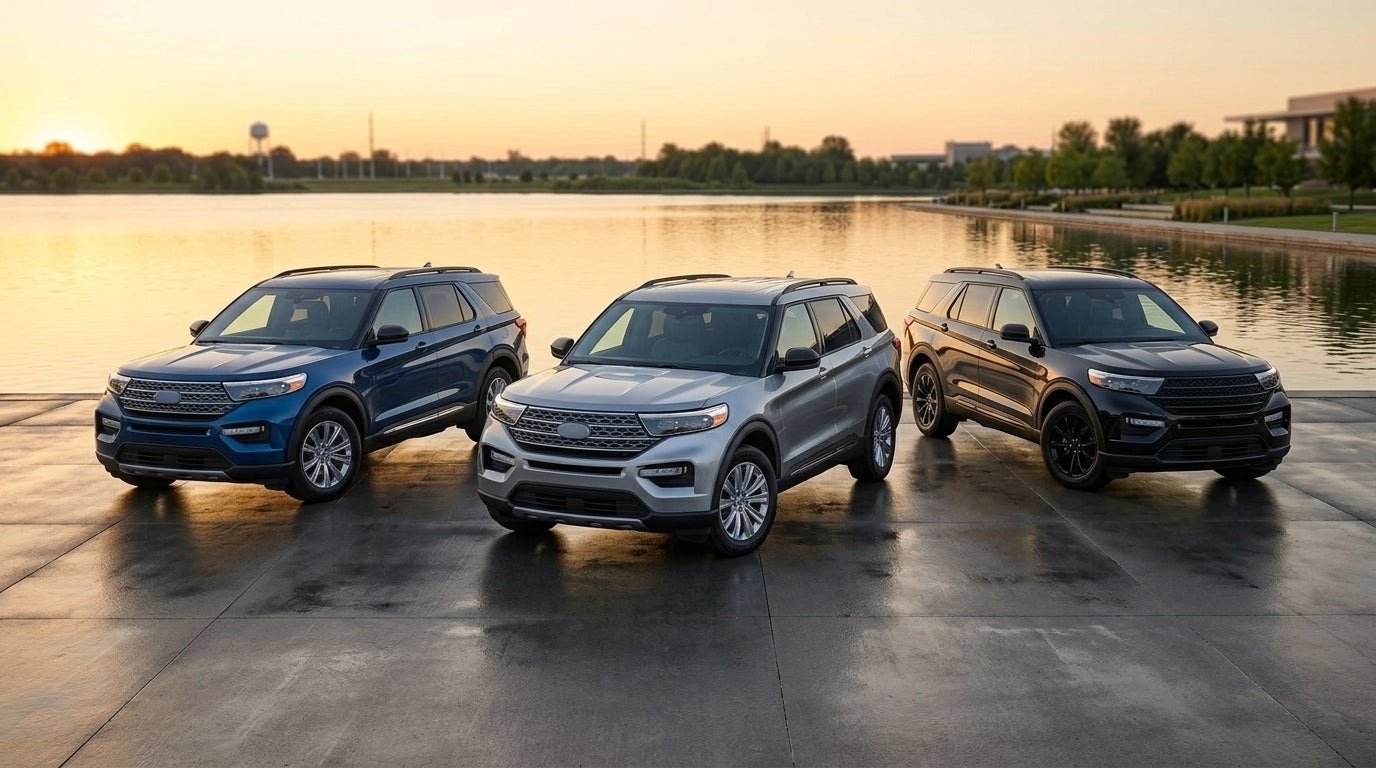 Three Ford Explorer SUVs in blue, silver, and black parked side-by-side near a lake at sunset. (Representative image for illustration purposes only. Actual vehicle may vary based on trim and configuration.)