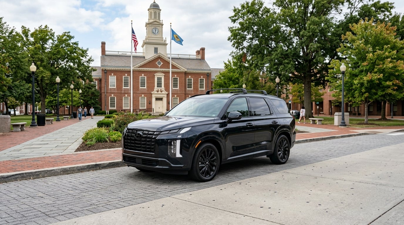 A black Hyundai Palisade parked on a paved path in front of a colonial brick building with a clock tower. (Representative image for illustration purposes only. Actual vehicle may vary based on trim and configuration.)