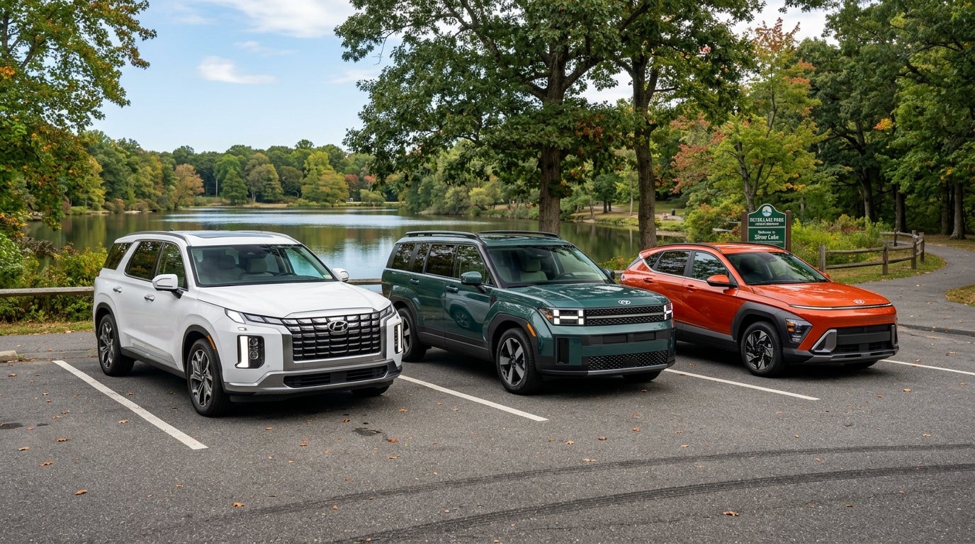 Three Hyundai SUVs—a white Palisade, green Santa Fe, and orange Kona—parked in a row near a park lake. (Representative image for illustration purposes only. Actual vehicle may vary based on trim and configuration.)