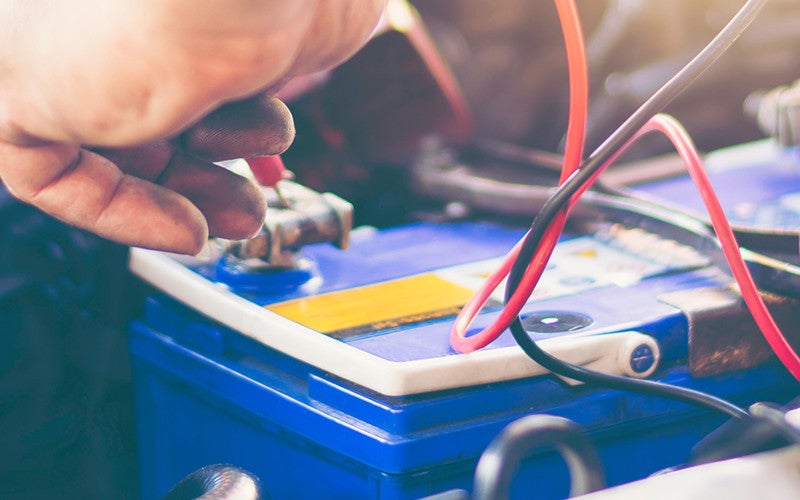 technician checking car battery. 