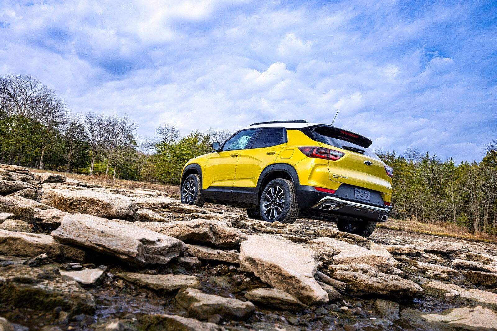 Chevy trailblazer parked on an uneven rocky landscape.