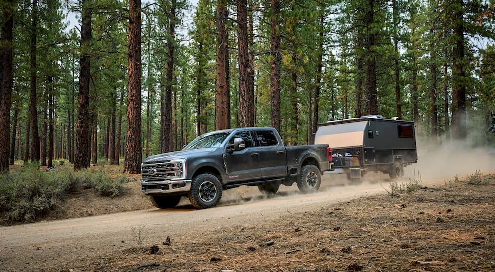 A grey 2026 Ford F-250 for sale in Rhinebeck from the side while towing.