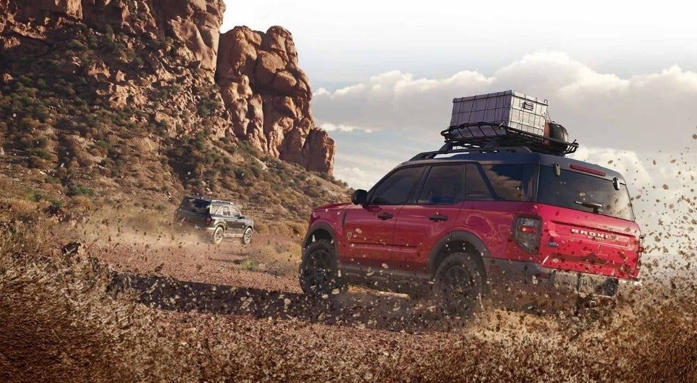 Rear view of a red 2025 Ford Bronco Sport Badlands kicking up mud while off-roading