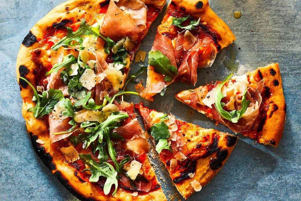 Aerial picture of a prosciutto pizza.