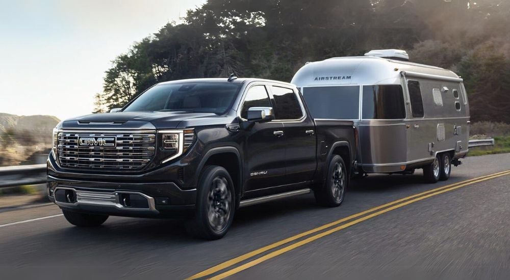 Black 2024 GMC Sierra 1500 Denali towing an Airstream trailer