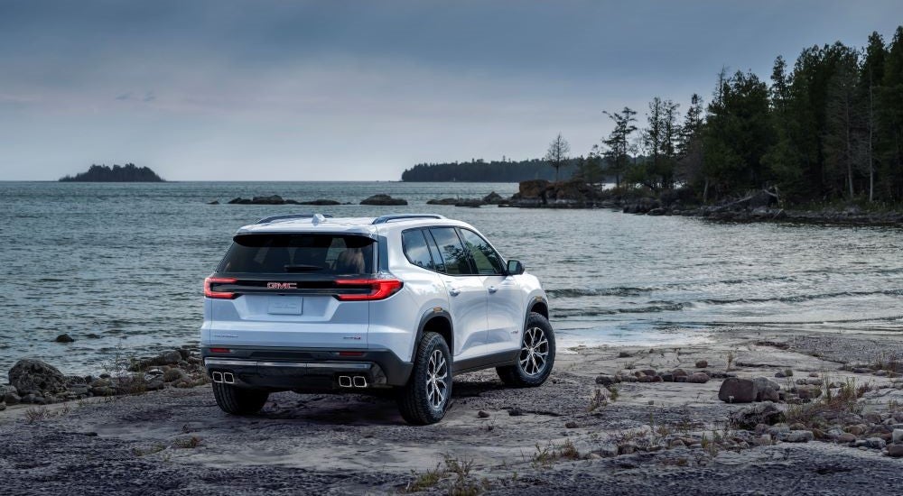 White 2024 GMC Acadia AT4 parked by a lake