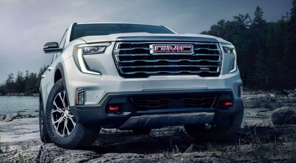 White 2024 GMC Acadia AT4 parked near a lake