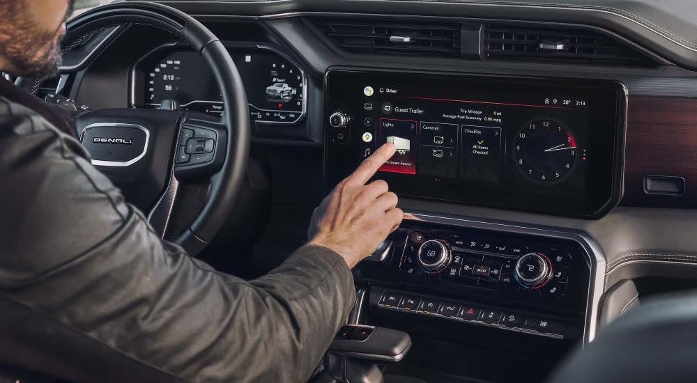 Person using the infotainment screen in a 2023 GMC Sierra 1500