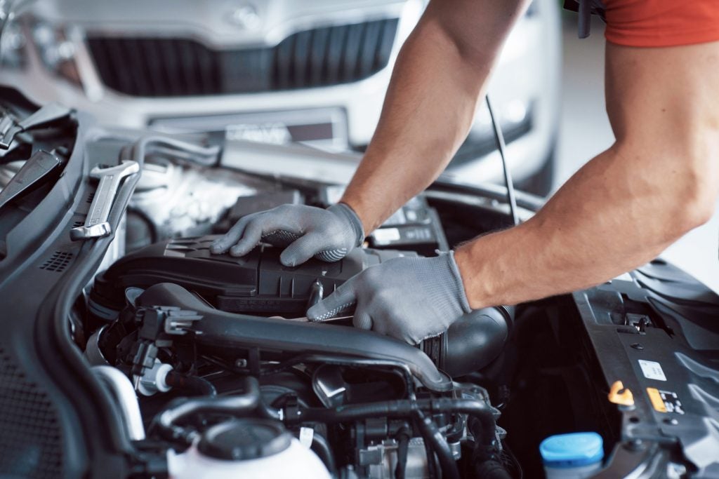 GMC technician performing routine summer service on a GMC vehicle.