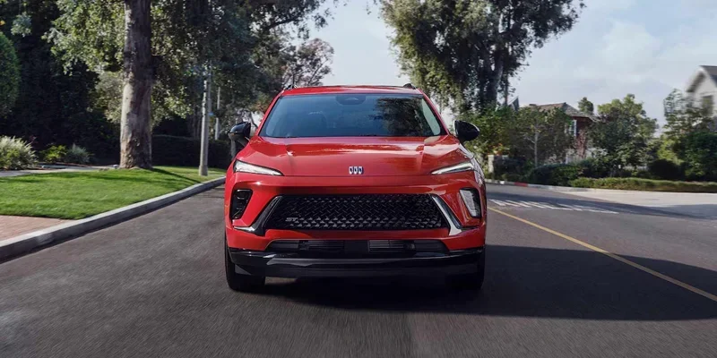 2026 Buick Envision in red, driving smoothly on a scenic highway