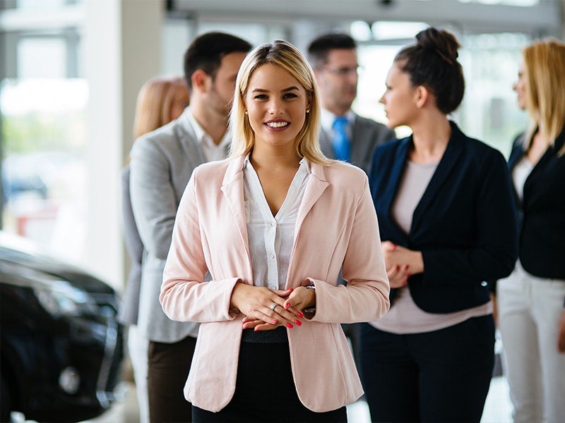 Patriot GMC male/female sales team confer while one woman smiles at the camera, ready to serve you in HOPKINSVILLE, KY