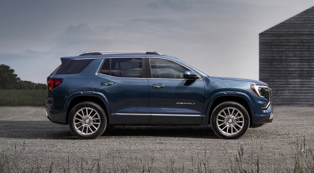 Blue 2026 GMC Terrain Denali is parked near a barn