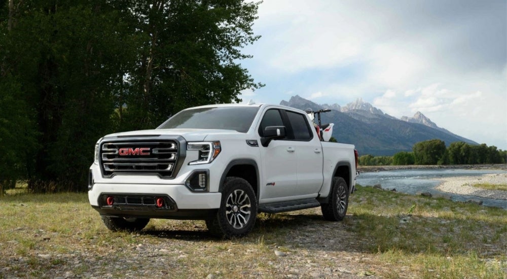 White 2021 GMC Sierra 1500 AT4 is parked near a riverbed after leaving a used GMC dealer