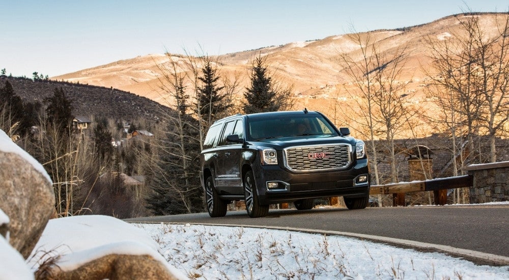 Black 2020 GMC Yukon XL Denali driving past mountains