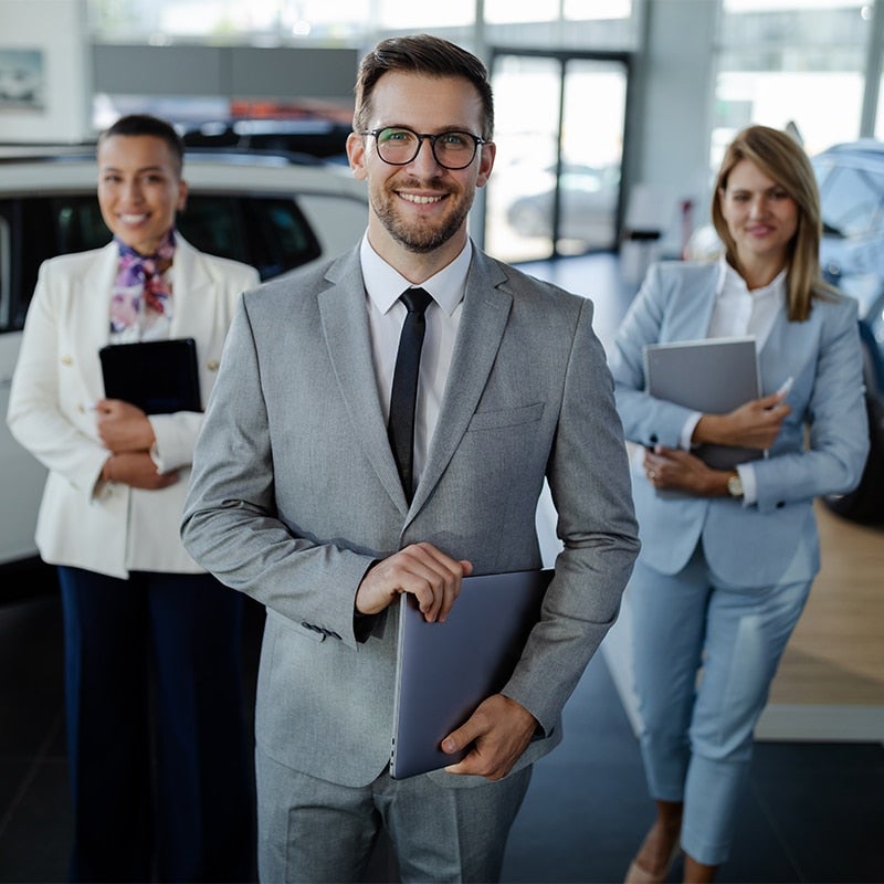 3 Boyd GMC of Emporia dealership salespersons welcoming customers in the showroom with their smiles