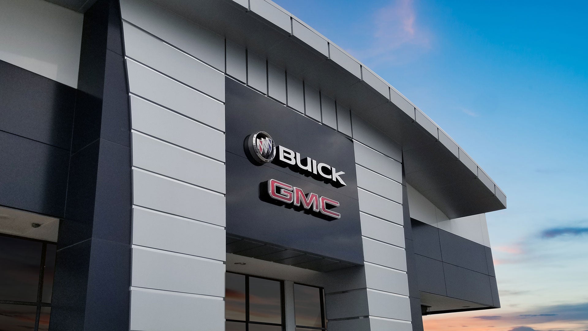 A grey and black building with the Buick and GMC logos above the door.