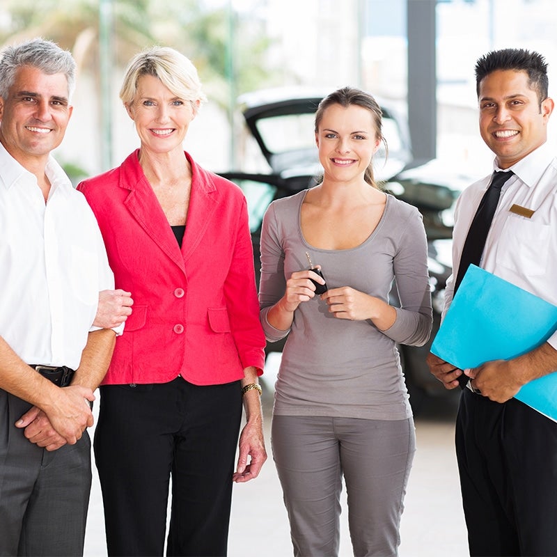 A couple and a sales team giving the keys to their band new GMC SUV at the GMC Dealership in Madras, OR