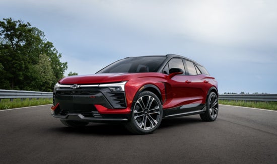 A red Chevy Blazer EV SUV with a black roof and windows is parked on a racetrack.
