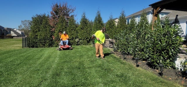 A man mowing the lawn with a lawn mower
