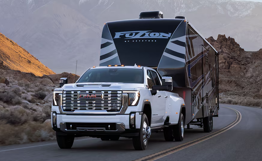 White GMC Truck Towing a Trailer
