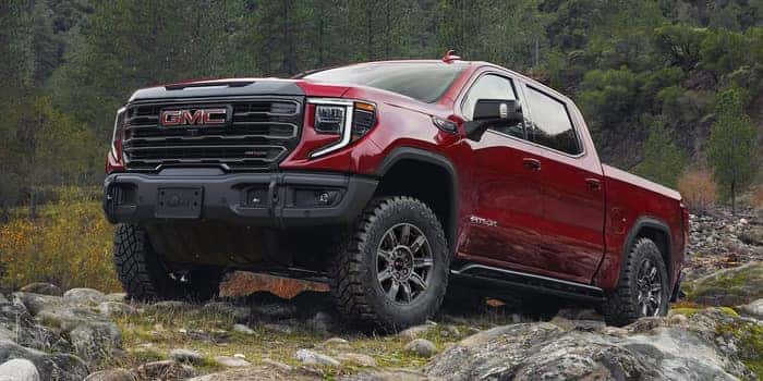 red GMC Sierra 1500 driving up on rocks
