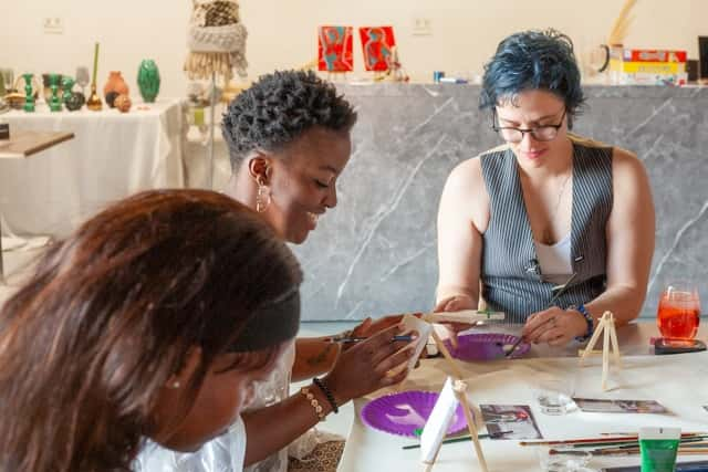 Three women painting and crafting at a table