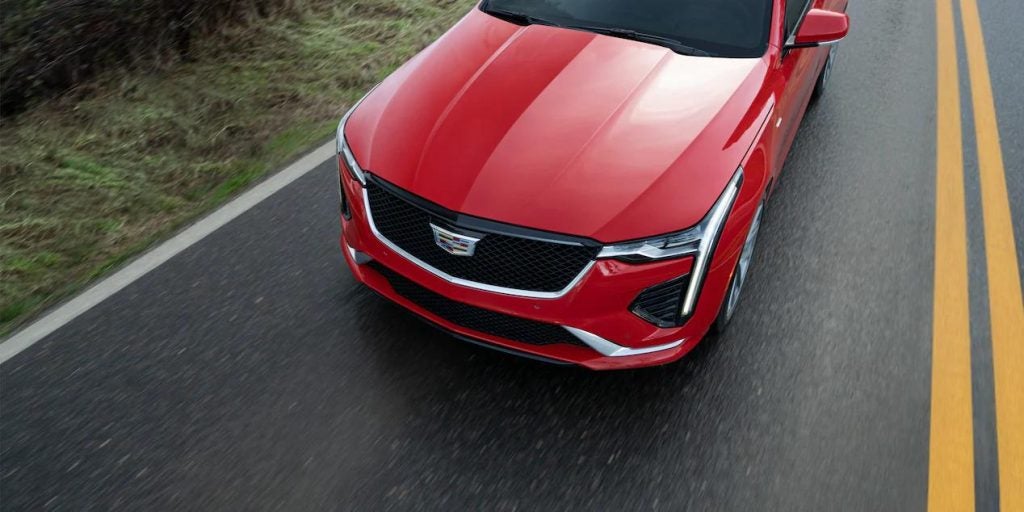Top-down vie of a red Cadillac CT4 driving down the road.