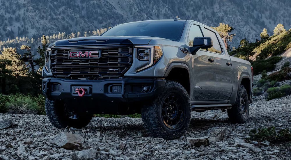 A grey 2024 GMC Sierra 1500 AT4X parked on a rocky mountainside.